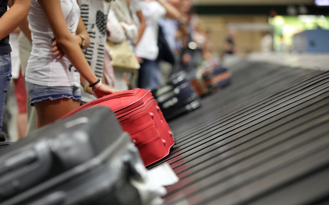 Suitcase on luggage conveyor belt in the baggage claim at airport