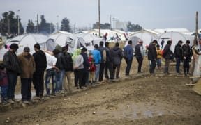 Refugees wait in queues to get food at the Idomeni refugee camp in Greece.