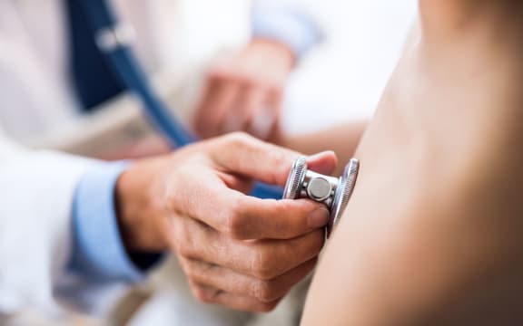 Doctor using stethoscope in examining a small boy