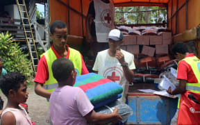 Members of the Red Cross hand out blankets.