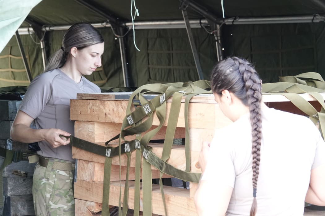 Army personnel rig together supplies to be dropped from aircraft during the training exercise.
