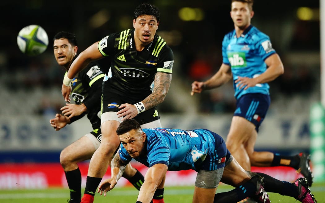 Blues midfielder Sonny Bill Williams, bottom, and Hurricanes wing Ben Lam keep their eyes on the ball.