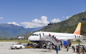 Passenger plane at Paro International Airport, Paro Rinpung Dzong in the distance, Paro, Bhutan, Himalayas, Asia (Photo by Christian Kober / Robert Harding Heritage / robertharding via AFP)