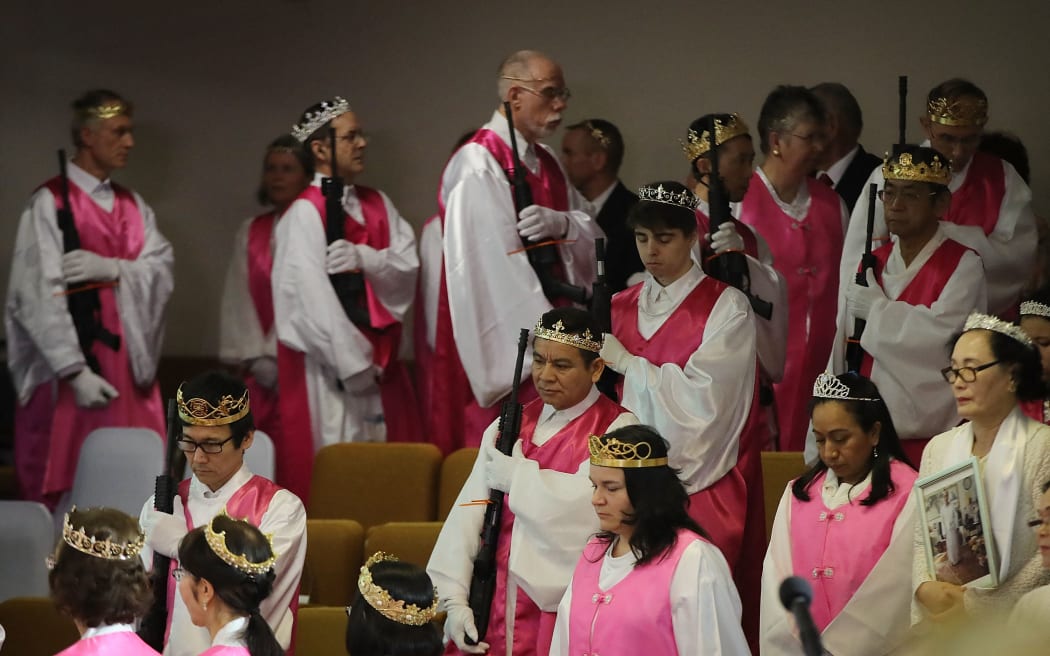 NEWFOUNDLAND, PA - FEBRUARY 28: Church officials hold AR-15 rifles during a ceremony at the World Peace and Unification Sanctuary on February 28, 2018 in Newfoundland, Pennsylvania. The controversial church, which is led by the son of the late Rev. Sun Myung Moon, believes the AR-15 symbolizes the "rod of iron" in the biblical book of Revelation, and it has encouraged couples to bring the weapons to a "commitment ceremony" or "Perfection Stage Book of Life Registration Blessing". Officials in the rural area in the Pocono Mountains have reportedly told elementary school parents that their children will be relocated on Wednesday to accommodate the AR-15 ceremony. The semiautomatic rifles are similar to the weapon used in a Florida high school shooting on February 14.   Spencer Platt/Getty Images/AFP (Photo by SPENCER PLATT / GETTY IMAGES NORTH AMERICA / Getty Images via AFP)