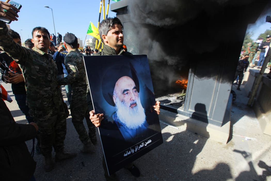 An Iraqi protester holds a picture of Iraq's top Shiite cleric Grand Ayatollah Ali Sistani during a demonstration against deadly US airstrikes on sites of a Shiite militia on January 1.