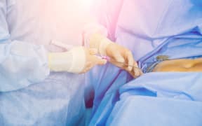 Arthroscope surgery. Orthopedic surgeons in teamwork in the operating room with modern arthroscopic tools. Hospital background