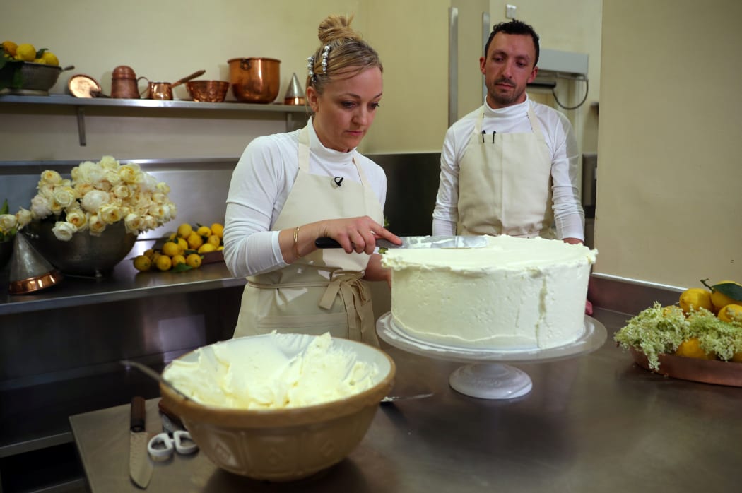NOwner of Violet Bakery in Hackney, east London, Claire Ptak, and head baker Izaak Adams, put the finishing touches on the wedding cake