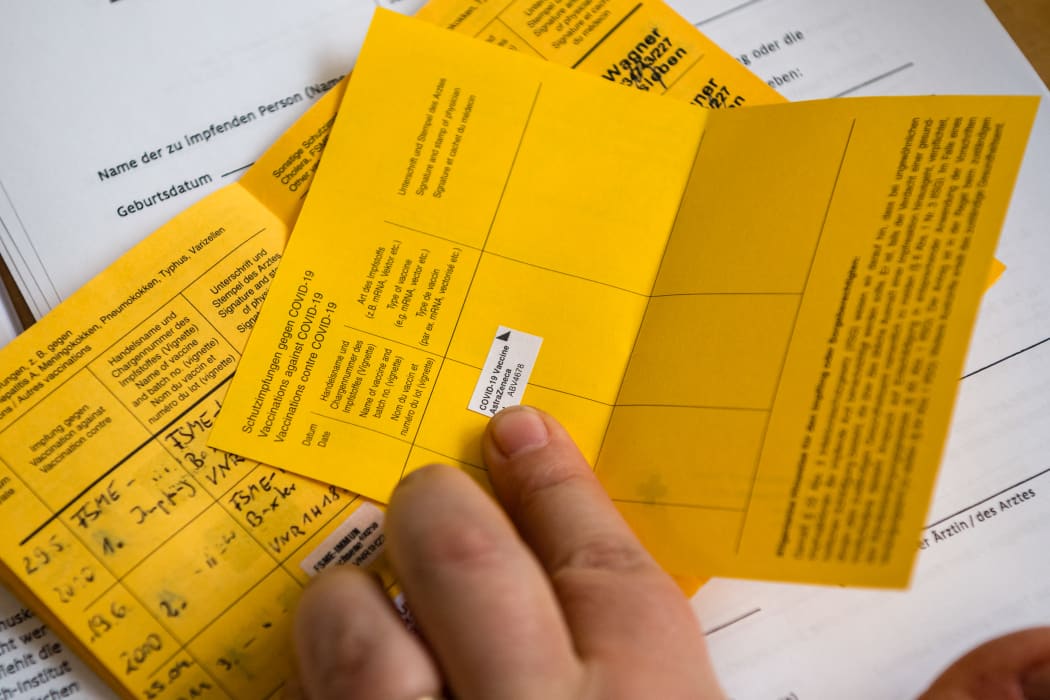 A healthcare worker records a vaccination on an International Certificate of Vaccination or Prophylaxis (ICVP), also known as the carte jaune or yellow card.