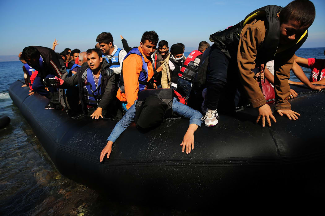 People disembark from a raft moments after arriving from Turkey on October 15, 2015 in Sikaminias, Greece.
