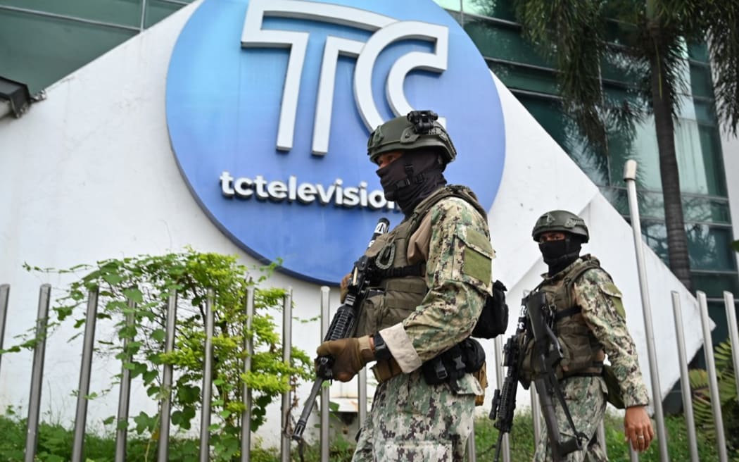 Ecuadorean soldiers patrol outside the premises of Ecuador's TC television channel after unidentified gunmen burst into the state-owned television studio live on air on January 9, 2024, in Guayaquil, Ecuador, a day after Ecuadorean President Daniel Noboa declared a state of emergency following the escape from prison of a dangerous narco boss. Gunshots rang out on live TV in violence-torn Ecuador as armed men carrying rifles and grenades stormed the studio shortly after gangsters vowed a "war" against the president's plans to reclaim control from "narcoterrorists". (Photo by MARCOS PIN / AFP)