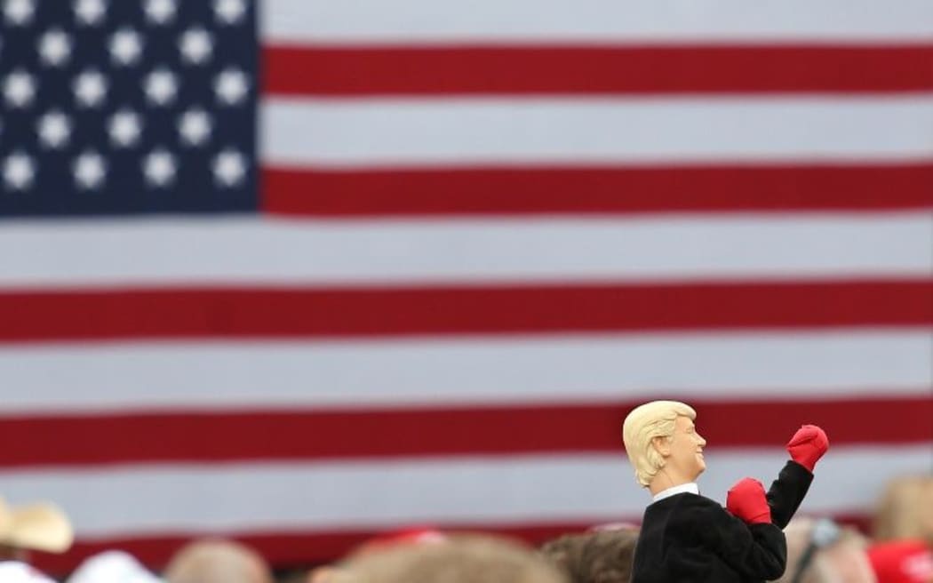 A supporter of Republican presidential nominee Donald Trump holds up a boxing hand-puppet in his likeness.