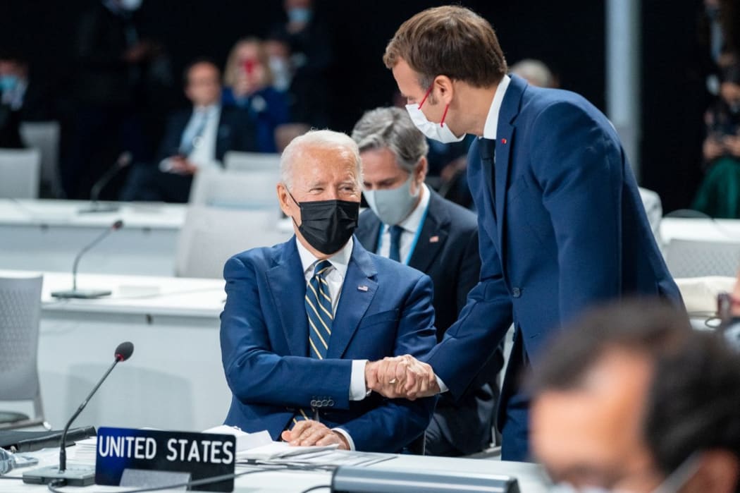 U.S President Joe Biden shakes hand with French President Emmanuel Macron at the United Nations Climate Change Conference COP26 in Glasgow, Scotland, on Monday Nov 1, 2021.