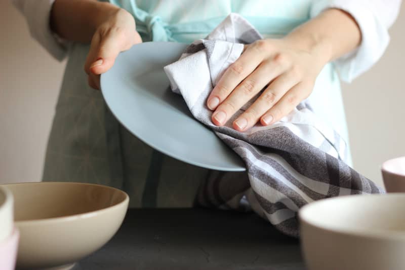 Housewife wipes the dishes with a towel. High quality photo