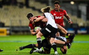 Scott Barrett of the Crusaders is tackled by Michael Little and Takuma Asahara of the Sunwolves during the Super Rugby match, Crusaders V Sunwolves,