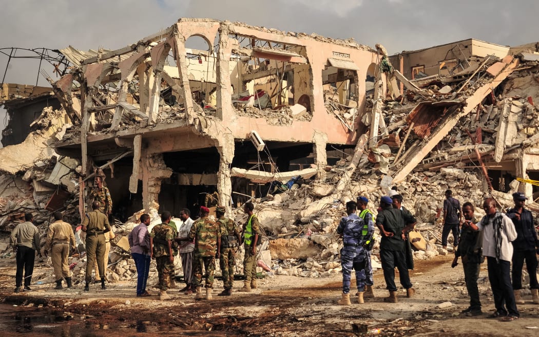 Somali security officers patrol on the scene of the explosion of a truck bomb in the centre of Mogadishu, on October 15, 2017.