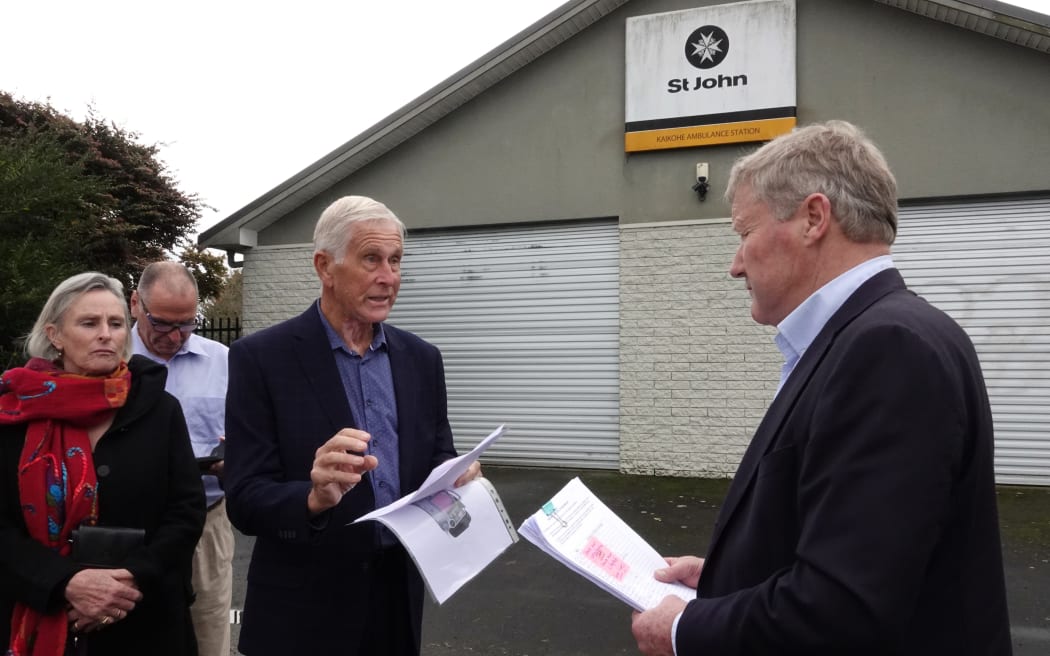 Jo Tucker, left, and St John volunteer Denis Orme centre, hand the 1157-signature petition to Northland MP Grant McCallum.