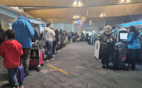 People queuing at Wellington Airport after all flights in and out of the capital were cancelled on 21 July 2022 due to the weather.