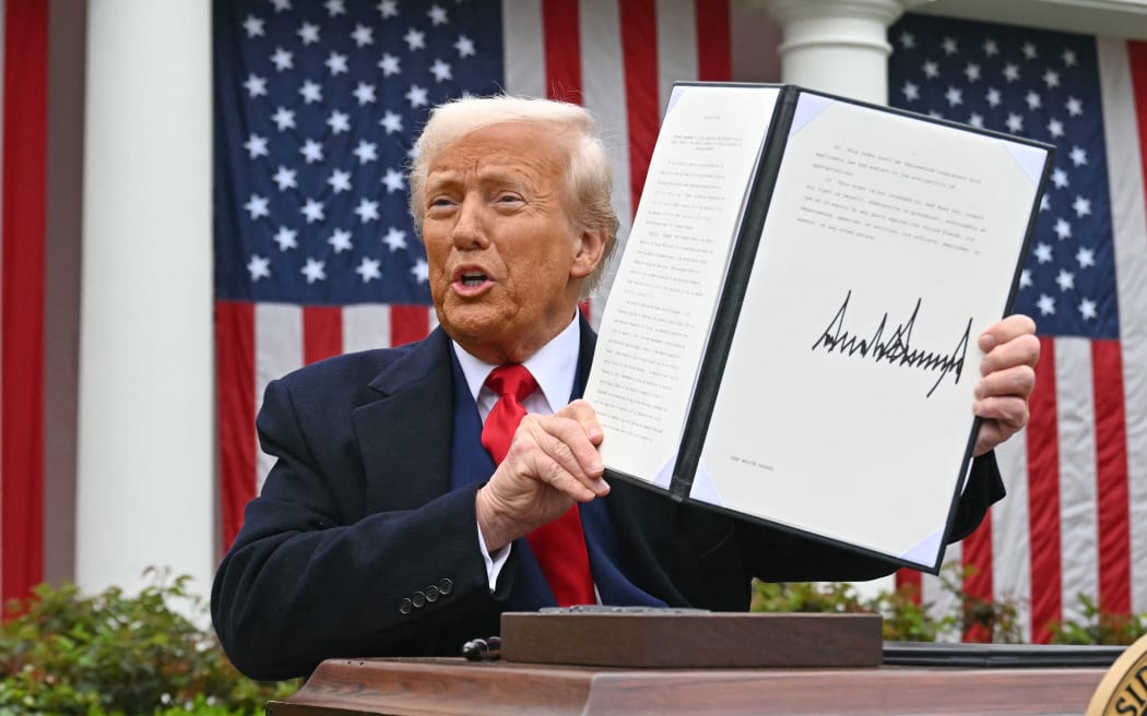 US President Donald Trump holds a signed executive order after delivering remarks on reciprocal tariffs during an event in the Rose Garden entitled "Make America Wealthy Again" at the White House in Washington, DC, on April 2, 2025. Trump geared up to unveil sweeping new "Liberation Day" tariffs in a move that threatens to ignite a devastating global trade war. Key US trading partners including the European Union and Britain said they were preparing their responses to Trump's escalation, as nervous markets fell in Europe and America. (Photo by SAUL LOEB / AFP)