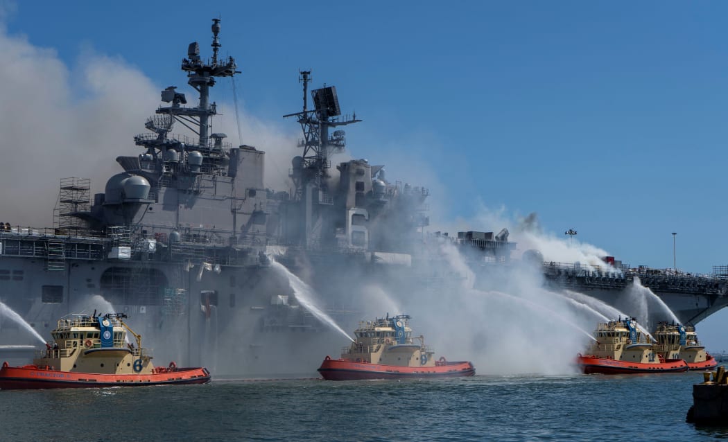 This US Navy photo released July 13, 2020 shows Sailors and Federal Firefighters combating a fire onboard the amphibious assault ship USS Bonhomme Richard (LHD 6) at Naval Base San Diego, July 12, 2020.