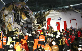 Health teams and fire brigade crews conduct operation at debris of a passenger plane after skidded off the runway in Istanbul Sabiha Gokcen International Airport, breaking into two, on February 05, 2020 in Istanbul, Turkey.
