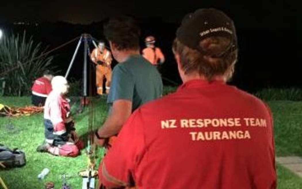 Police and volunteers worked to bring up the trapped teenager in Tauranga.