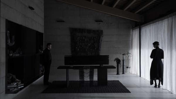 A shot from the film Went Up the Hill of actor Dacre Montgomery and actress Vicky Krieps standing on either ends of a room.