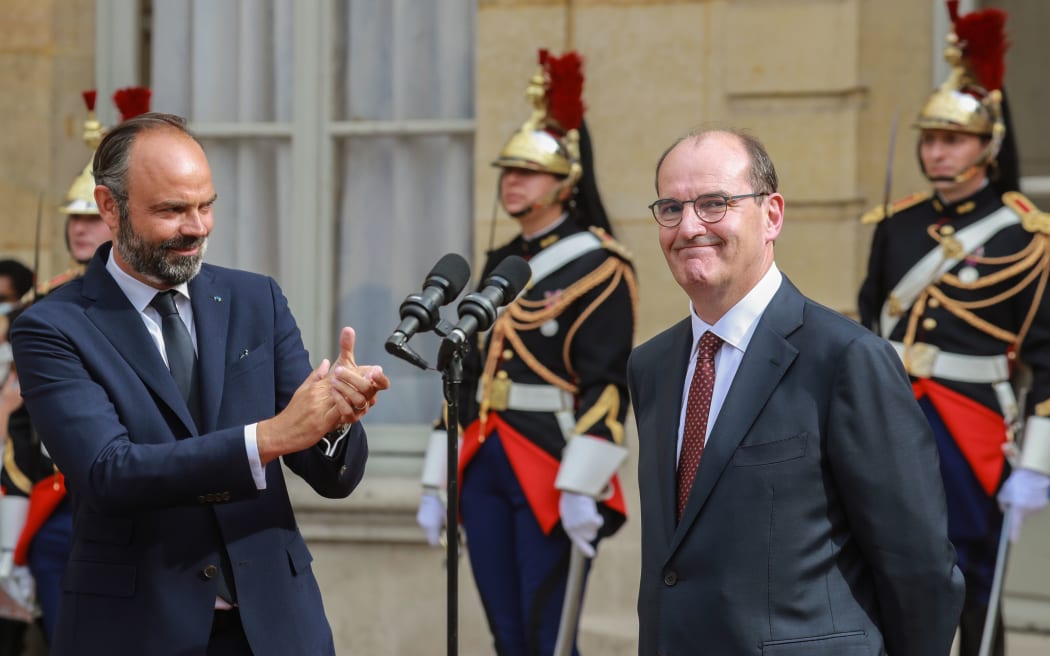 Former French Prime Minister Edouard Philippe (L) and newly-appointed Prime Minister Jean Castex react as they give a speech during the handover ceremony, in the courtyard of the Matignon Hotel in Paris on July 3, 2020. (Photo by Ludovic Marin / AFP)