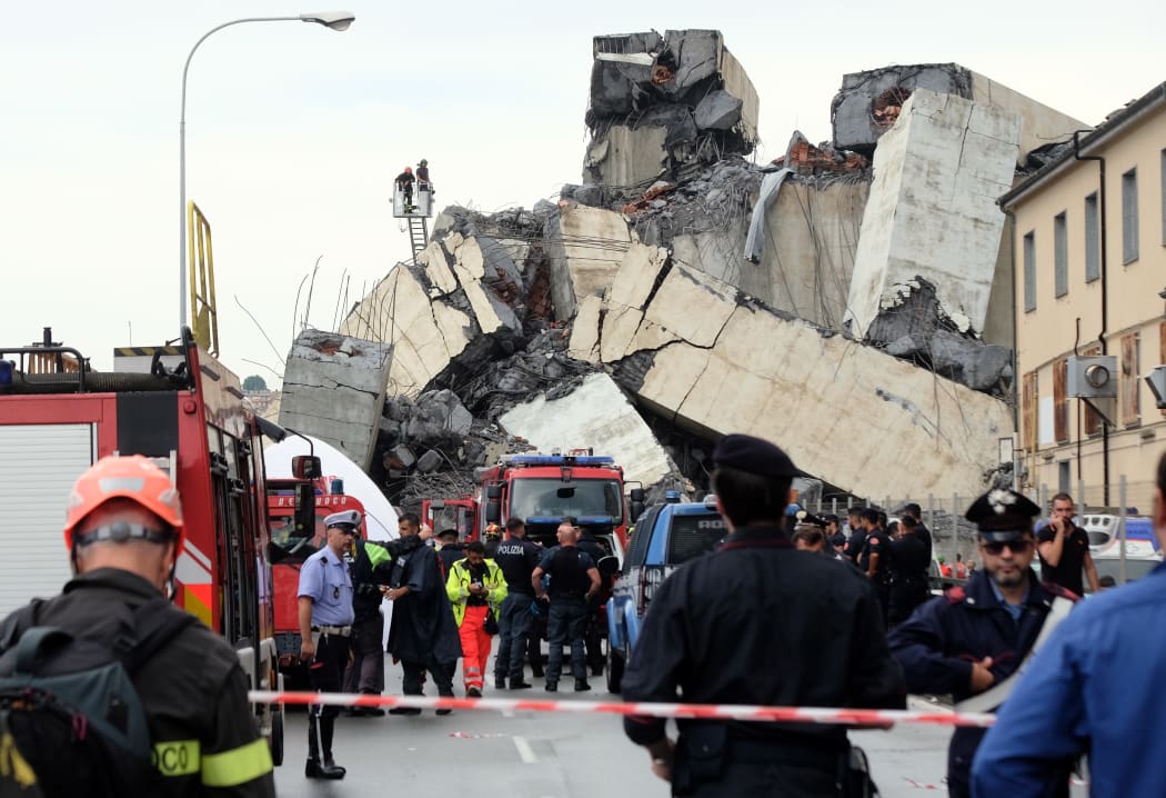 Rescuers are at work amid the rubble of a section of the Morandi motorway bridge that collapsed.
