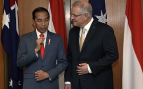 Indonesia's President Joko Widodo (L) and Australia's Prime Minister Scott Morrison (R) speak during a signing ceremony at Parliament House in Canberra on February 10, 2020.