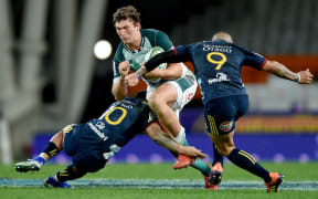Bulls player JT Jackson crashes into the tackle of Highlanders pair Josh Ioane, left, and Aaron Smith.
