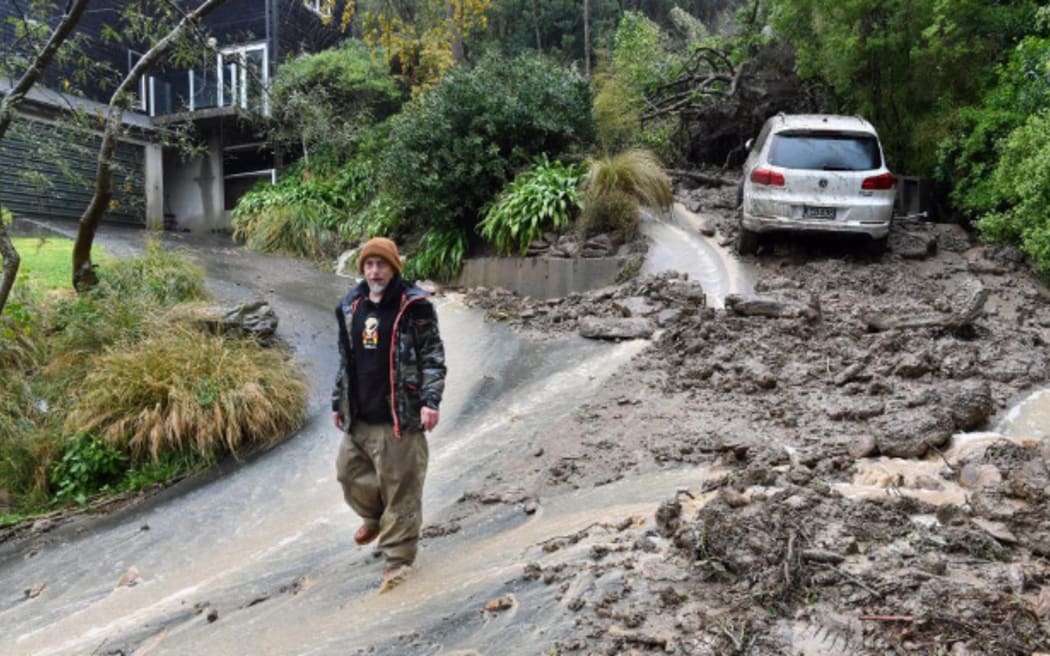 Macandrew Bay resident Shaun Campbell in front of a landslip that buried his neighbour’s car, on 4 October, 2024.