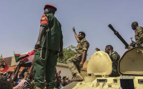 Sudanese forces celebrate after officials said the military had forced longtime autocratic President Omar al-Bashir to step down after 30 years in power in Khartoum, Sudan.
