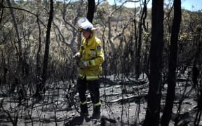 A firefighter proceeds to dose bush fire at the Woodford residential area in Blue Mountains on November 12.