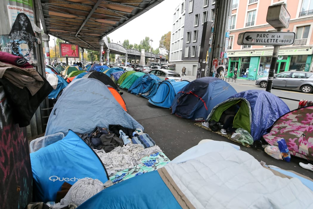 Refugees carrying their belongings camp along avenue de Flandre, Place de la Bataille-de-Stalingrad in Paris, France on October 29, 2016.