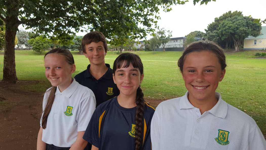 Group of 11 and 12 year olds stand on edge of school field