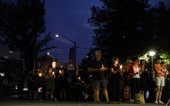People hold lit candles during a vigil in honour of the victims of a stabbing spree that killed ten people in Saskatchewan, Canada.