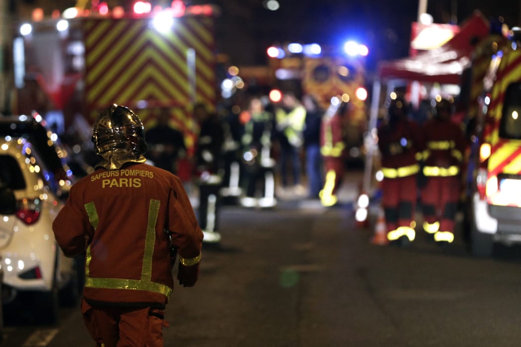 Firefighters are seen near a building that caught fire in the 16th arrondissement in Paris.