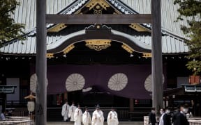 Priests walk at the outer shrine during a Shinto ritual of the annual spring festival at the Yasukuni shrine in Tokyo.