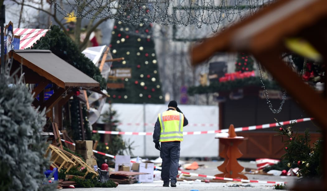 A policeman walks at the Christmas market near the Kaiser-Wilhelm-Gedaechtniskirche (Kaiser Wilhelm Memorial Church), the day after a terror attack, in central Berlin, on December 20