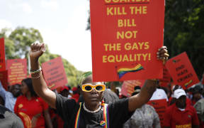 Uganda’s queer activist Papa De raises a fist outside the Uganda High Commission during a picket against the country’s anti-homosexuality bill in Pretoria on April 4, 2023. A proposed law, officially known as the Anti-Homosexuality Bill 2023, is ready to be sent to President Yoweri Museveni, who is facing calls from the United Nations and the United States to reject the legislation. The bill was passed in a chaotic parliamentary session with many amendments, and neither lawmakers nor analysts are clear about what exactly the legislation dictates. (Photo by Phill Magakoe / AFP)