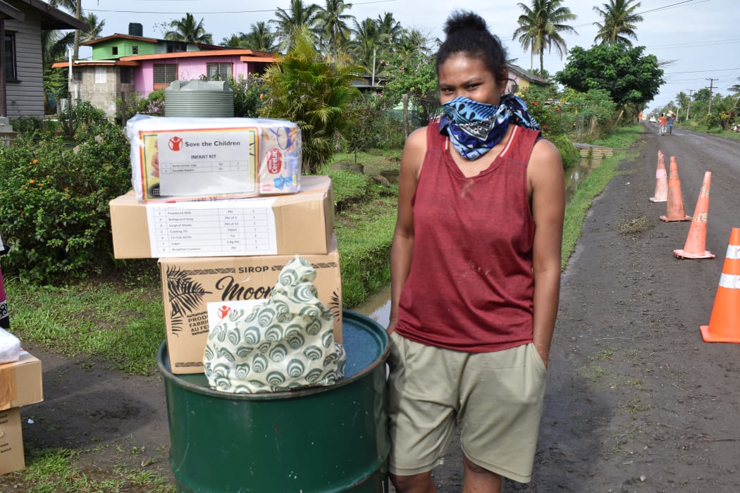 A woman picking up grocery supplies for her family from Save the Children in Fiji.