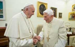 (FILES) This file handout picture taken and released by Vatican Media on December 21, 2018, shows Pope Francis (L) meeting with Pope Benedict XVI (R) at the Vatican.