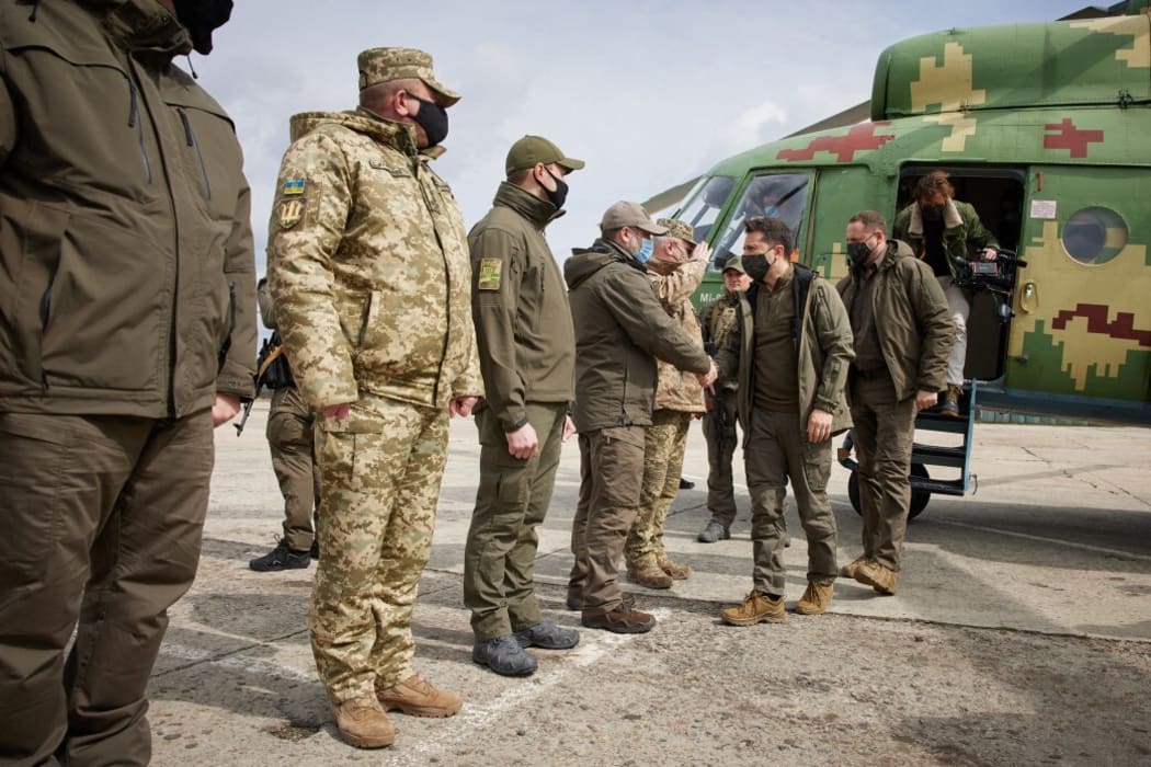 Ukrainian President Volodymyr Zelensky  shakes hands with soldiers during his visit to a front in Donbass, Ukraine.
