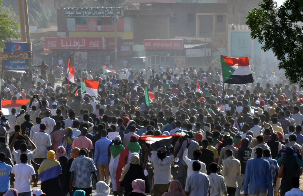 Sudanese protesters carry national flags during a demonstration calling for a return to civilian rule, Omdurman, 21 November 2021.