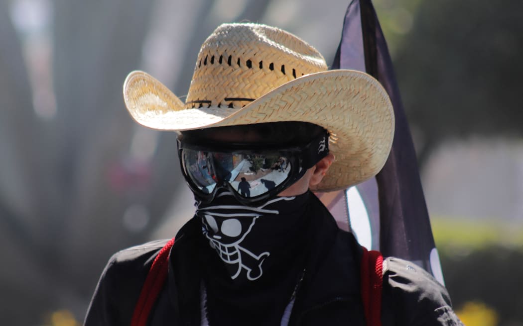 A person participates in the self-proclaimed 'Gen Z' demonstration against the Mexican government following the murder of Uruapan Mayor Carlos Manzola, while Mexico's President Claudia Sheinbaum questions the legitimacy of the movement in recent days, in Mexico City, Mexico, on November 15, 2025. (Photo by Carlos Santiago/Eyepix Group/NurPhoto) (Photo by Eyepix / NurPhoto via AFP)