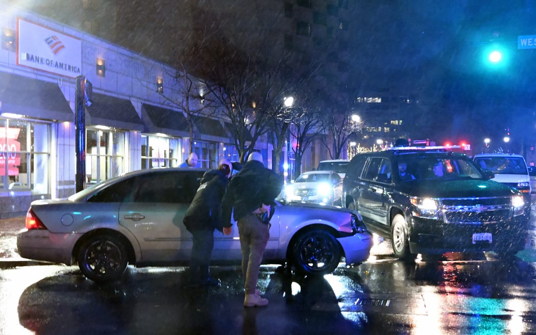 Members of the US Secret Service rush to a car, after it hit a motorcade SUV, as US president Joe Biden was leaving his campaign headquarters in Wilmington, Delaware on December 17, 2023. (Photo by ANDREW CABALLERO-REYNOLDS / AFP)