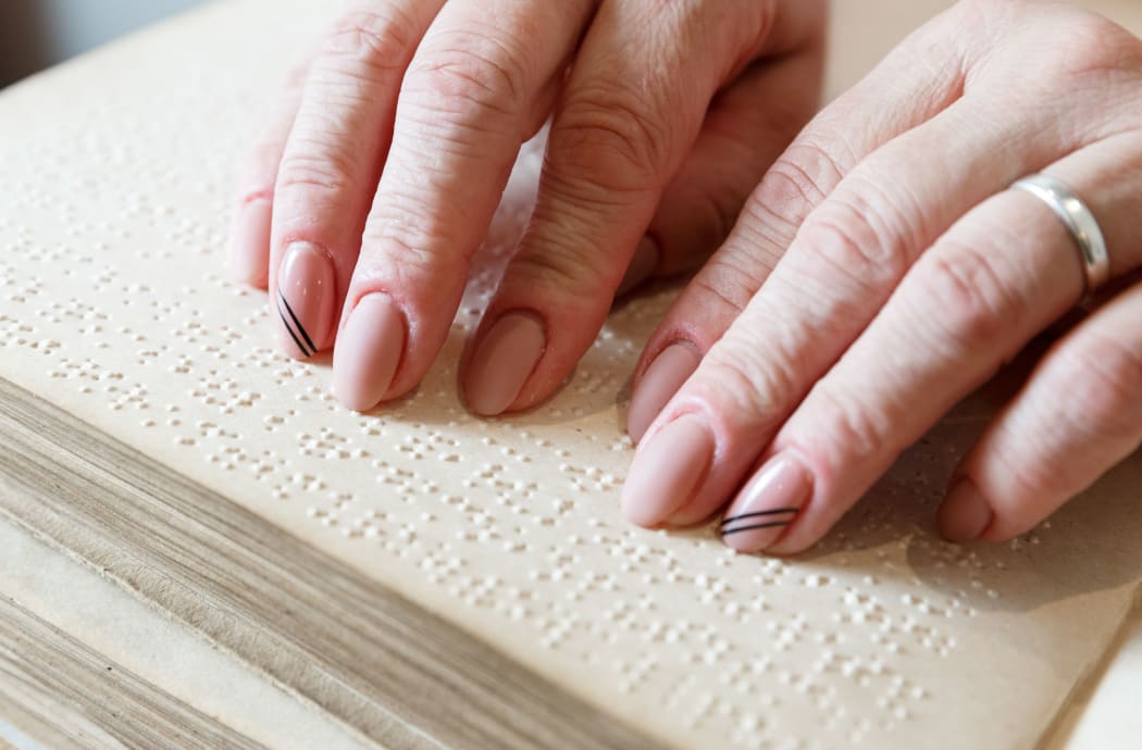 close up view of woman reading braille text on old book