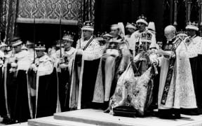 King George VI, seated upon the throne in full regalia during his coronation in 1937