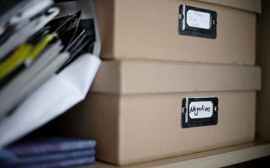 Boxes of old photos stacked in the wardrobe at Ella's family home.