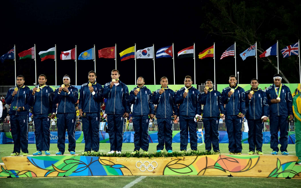 Fiji stand on the medal podium after winning gold during the Men's rugby sevens Final.